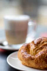 Latte coffee with croissant, breakfast in the cafeteria