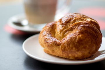 Latte coffee with croissant, breakfast in the cafeteria