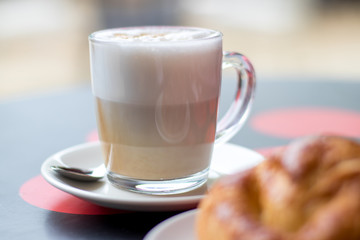 Latte coffee with croissant, breakfast in the cafeteria
