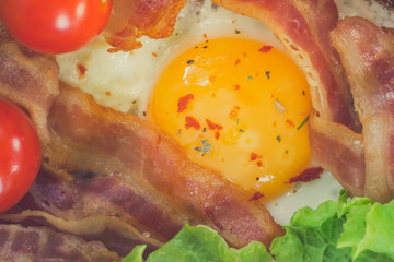Sunny Side Up Eggs with crispy fried bacon, arugula and tomatoes