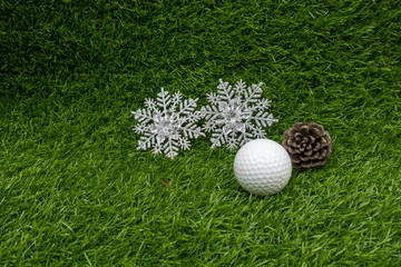 Golf Christmas with golf ball pine cone and snowflake on green grass