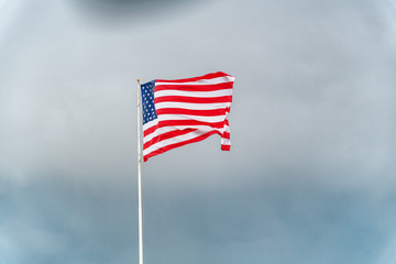 American flag waving against stormy sky