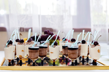 Traditional Italian tiramisu dessert with chocolate sauce in a glass on a mirrored tray