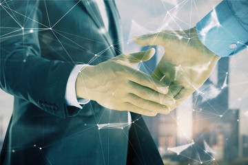 Double exposure of abstract technology drawing on cityscape background with two businessmen handshake. Concept of tech role in business