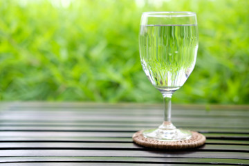 glass of water on background of green leaves