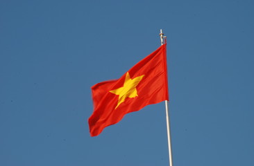 Vietnamese flag waving in the wind with clear blue sky