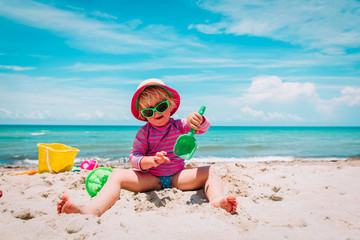 cute happy girl play with sand on beach