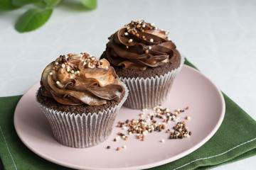 chocolate cupcakes on a pink plate with sprinkling