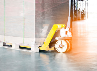 hand pallet truck with cargo pallet at warehouse.
