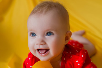 baby, portrait of a little girl with blue eyes closeup, yellow background, red clothes