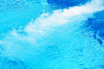 Pulsating blue pool water with jets of incoming water 