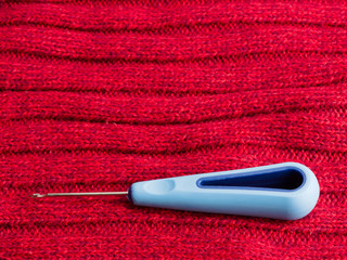 Sewing still life sewing awl on background of red wool fabric