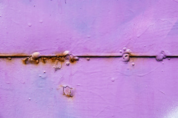 Rusty line in the middle of a purple wall