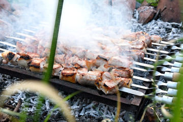 Pork shashlyk preparing on barbecue grill over charcoal from grapevine. Kakhetian cooking method