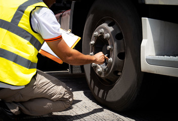 truck driver is inspecting safety tires truck.