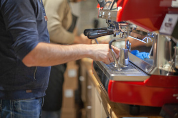Barista makes coffee in the coffee machine another Barista teaches you to do it