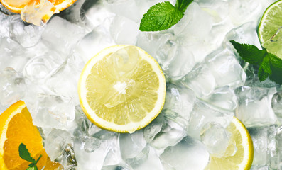 Refrehing summer fruits for lemonade on ice cubes background