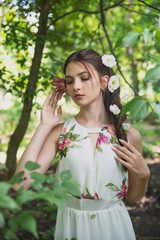 beautiful girl with lilies in her hair, flowers in the luxurious dark hair of a young lady