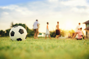 Action sport outdoors of kids having fun playing soccer football for exercise in community rural area under the twilight sunset sky. Fresh and vibrant image with anonymous people.