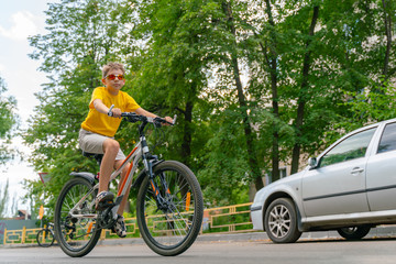 Teenager rides a bicycle on the roadway