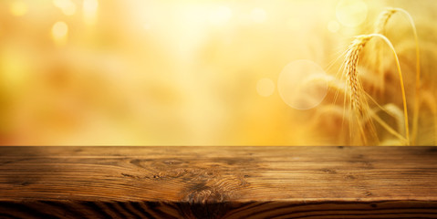 Golden ears of wheat with wooden table