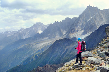 Fototapeta na wymiar Woman Hiker with backpacks relaxing on top of a mountain and enjoying the view of valley