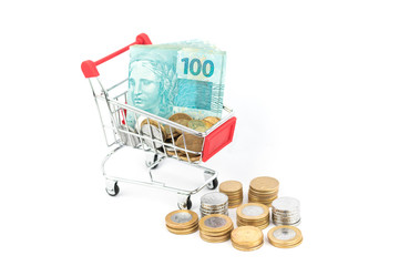 Stacks of brazilian coins and notes on shopping cart or supermarket trolley, business finance shopping concept. Brazil money.