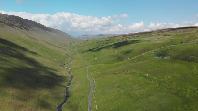 A forward moving shot of the Barbon Beck Valley, Carnforth, Lancashire demonstrating the shadow of the clouds over the stunning and undulating landscape.