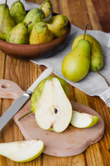 fresh ripe pears in a clay bowl on a dark wooden background. Rustic style