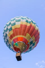 Fototapeta premium flying balloon with passengers in a basket against the blue sky at the festival of Aeronautics in Pereslavl-Zalessky Russia summer evening