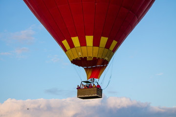 Fototapeta premium flying balloon with passengers in a basket against the blue sky at the festival of Aeronautics in Pereslavl-Zalessky Russia summer evening