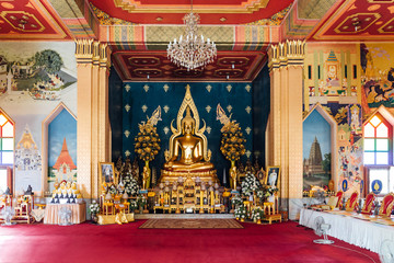 Fototapeta premium Interior of Thai Monastery (Thai Temple) decorated with Thai art and Golde Lord Buddha Statue in the center at Bodh Gaya, Bihar, India.