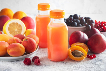 composition of berries, fruits and bottled juice on a gray background, copy space, close-up