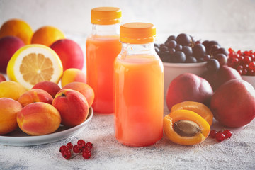 composition of berries, fruits and bottled juice on a gray background, copy space, close-up