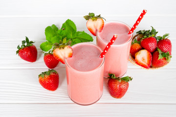 Strawberry yogurt fruit juice smoothie pink colorful fruit juice milkshake blend beverage healthy high protein the taste yummy In glass drink episode morning on white wood background.