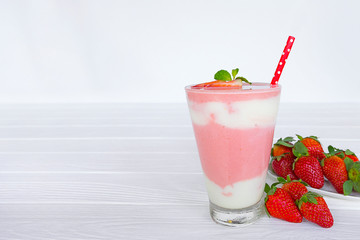 Strawberry yogurt fruit juice smoothie pink colorful fruit juice milkshake blend beverage healthy high protein the taste yummy In glass drink episode morning on white wood background.