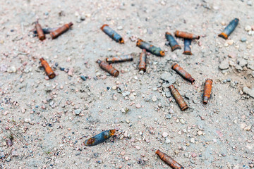 lots of old rusty gun casings on the ground. Consequences and remnants of war