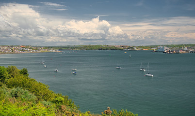 A view across Milford Haven to Neyland, the Cleddau Bridge and Pembroke Dock on a summer day with clouds