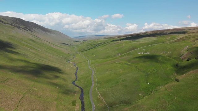 A static shot of the Barbon Beck Valley, Carnforth, Lancashire demonstrating the shadow of the clouds over the stunning and undulating landscape.