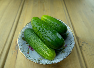 Green cucumbers on a plate on the table