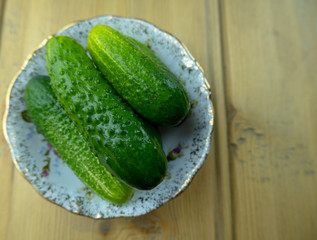 Green cucumbers on a plate on the table