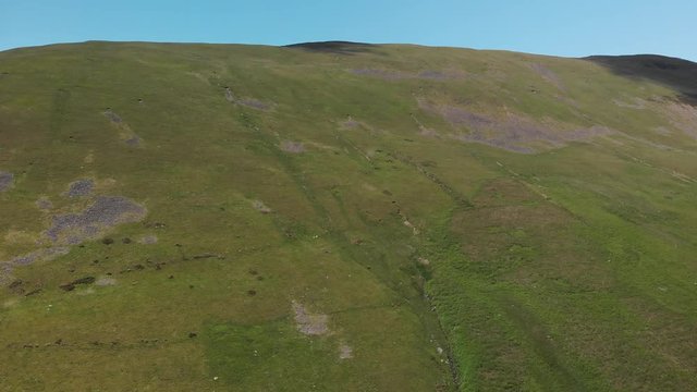 An aerial shot flying into a stunning country hillside. The footage shows lush green English countryside. Taken at Barbon Beck, Carnforth in June to capture the best of the nature in the area.