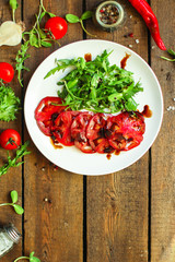 tomatoes salad with sunflower seedlings microgreen (carpaccio, sliced ​​raw vegetables). food background. top view. copy space