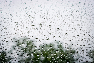 Large drops of water on the glass. Raindrops on the windshield of a car against the background of the sky sky.
