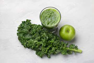 Green smoothie with kale cabbage and apple on a gray background. delicious healthy vegan food	