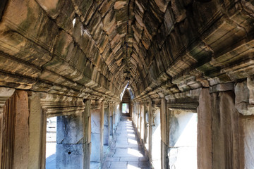 Ancient stone corridor bathed in sunlight. Stone vaults. Ancient stonework.