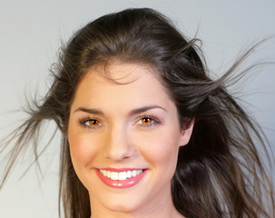 Jeune femme brune souriante avec un top rose