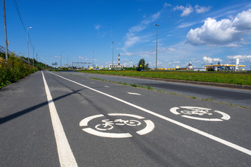 Summer landscape with two road signs "Bicycle path" on asphalt pavement close-up