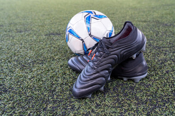 football stud shoes with soccer ball on artificial grass field