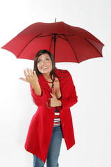 Jeune femme brune souriante sous un parapluie rouge